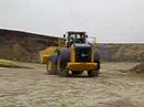 Deere 844J feeding a clay hopper