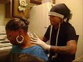 A lady getting her daughters name tattooed on the back of her neck.