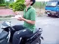 Um homem pilotando uma scooter enquanto come macarrão