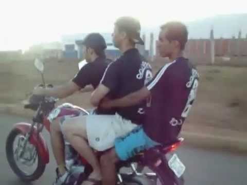 Three guys trying to wheelie motor bike
