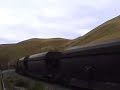 A loaded coal train screams through an S bend, dynamic brakes in full cry.