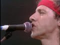 13.07.1985, london (wembley stadium), england

you get a shiver in the dark
its been raining in the park but meantime
south of the river you stop and you hold everything
a band is blowing dixie double four time
you feel all right when you hear that music ring

you step inside but you dont see too many faces
coming in out of the rain to hear the jazz go down
too much competition too many other places
but not too many horns can make that sound
way on downsouth way on downsouth london town

you check out guitar george he knows all the chords
mind hes strictly rhythm he doesnt want to make it cry or sing
and an old guitar is all he can afford
when he gets up under the lights to play his thing

and harry doesnt mind if he doesnt make the scene
hes got a daytime job hes doing alright
he can play honky tonk just like anything
saving it up for friday night
with the sultans with the sultans of swing

and a crowd of young boys theyre fooling around in the corner
drunk and dressed in their best brown baggies and their platform soles
they dont give a damn about any trumpet playing band
it aint what they call rock and roll
and the sultans played creole

and then the man he steps right up to the microphone
and says at last just as the time bell rings
thank you goodnight now its time to go home
and he makes it fast with one more thing
we are the sultans of swing