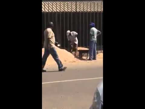 Zwei Arbeiter bei der schwerst Arbeit mit Schubkarre