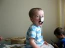 Baby balances a spoon on his nose.