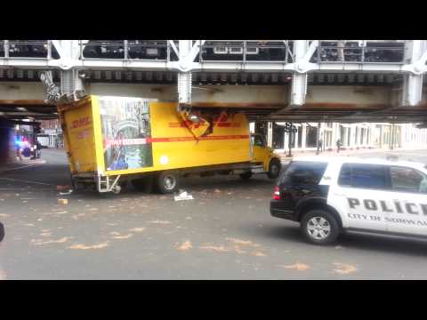 DHL truck gets stuck under train bridge