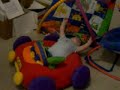 JJ falls over and lays down in his car toy