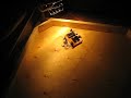The same first prototype robot on the unpainted play surface. The final play surface will have four 500W lights that switch on and off. The goal is for the photovore to move from light to light to stay alive (because its only source of power is solar energy). This prototype can store up to 7.5J of energy in its super capacitor and consumes an average maximum of 180mW. Which means on a full charge this photovore can run for about 42 seconds before it dies. This prototype has light sensors to detect where the light is but they haven't been properly mounted and the software hasn't been completed at this time. This was done for the final year project in electrical engineering at Dalhousie University.