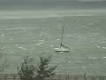 Sailboats on the bay in trouble with high winds.