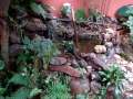 Lago ornamental com cacheira feito com pedras e acabamento natural. Paisagismo de mata atlantica ao estilo tropical 