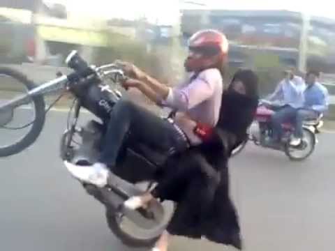 wheeling - A Pakistani boy wheeling on bike with her girl friend .Pakistani Boy Crazy Bike riding with girl friend on the Lahore heavy traffic road so much dangerous.