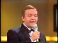 Het is 1987.  Op de vooravond van de oprichting van de eerste Vlaamse commerciële TV-zender VTM (1989) pakt de toenmalige BRT uit met een grootschalige live-show in samenwerking met de Nationale Loterij: 'Pak De Poen -- De Show van Eén Miljoen'.  Manu en René Verreth, twee acteurs uit het jaren voordien immens populaire 'De Collega's', een mooi gemaakte humoristische serie over het reilen en zeilen van een groep ambtenaren op één of ander ministerie, zullen het geheel presenteren.De show wordt een regelrechte ramp: René en Manu Verreth drukken zich uit in een kaduuk soort ambtenarentaal, de studiolichten vallen uit, knoppen die de kandidaten moeten gebruiken om 'af te drukken' doen het niet, afstandsbestuurde wagentjes voor één van de showproeven worden gestoord door draadloze microfoons, de presentatoren worstelen met de spelregels én dus ook met de jury, de in die tijd meer dan beruchte BRT-telefooncentrale toont zich van de meest nukkige kant, en tot overmaat van ramp vergeet René Verreth de naam van Percy...  Percy....    juist, dames en heren!Nadien volgen nog twee afleveringen van de show, maar die worden gepresenteerd door Luc Appermont.  Na drie afleveringen wordt de show afgevoerd.Op de VRT waren tot enkele jaren geleden heel af en toe nog wel eens héél korte fragmenten uit die beruchte show te zien, maar de VRT lijkt het geheel liefst zo vlug mogelijk te willen vergeten.  De originele bandopname van de show zou, althans dat beweren kwatongen, door René en/of Manu ontvreemd zijn uit het archief van de openbare omroep, maar niets is minder waar.  Getuige daarvan de hele uitzending die je nu, 20 jaar na uitzending, hier integraal te zien krijgt.  Zorg dat je niet gestoord kan worden, en go ahead, het is de moeite waard!!