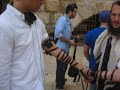 putting on tefilin at teh kotel for...
