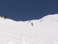 skiing throws snow over camera