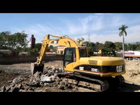 EXCAVADORA CAT - Tres excavadoras Caterpillar 320C trabajando en un terreno, una excavadora con rotomartillo hidraulico, otra excavadora cargando un camion con escombros. est...