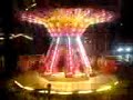 Weihnachtskarussell bei Nacht mit Kirchenglocken