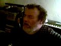 left handed frank fish strums a right handed acoustic guitar and sings 'oh god please tell me....