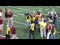 Jerry Kill leaves the field after his first victory as the Head Coach of the University of Minnesota Golden Gophers against the Miami University (Ohio) Redhawks. As he leaves the field his wife, Rebecca, comes up to him and gives him a hug and kiss, and the student section chants his name (Jerry). Coach Kill suffered a seizure during the final moments of the previous game against New Mexico State, causing a delay in the final moments as he was taken off the field in a stretcher (his team would fail in its final drive after the game resumed). After leaving the hospital, and still shaky, Kill opted to return to the sideline and guided the Gophers to their first victory in 2011, with a defensive stand as time expired. The outpouring of support came with his return to the sideline, the win, and the respect he had from the Gophers fanbase.