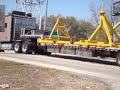 kenworth hauling an oversize load escorted by a cadillac escalade