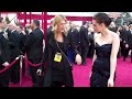 kristen stewart walks by fans at the 2010 academy awards.