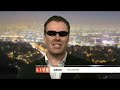 ben price as arnold schwarzenegger being interviewed by james o'neill in a mock satellite interview