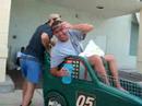 Guy in a racecar-shopping cart wearing a hairnet