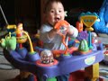 Playing with his roll-a-round in his exersaucer 7 months old