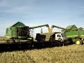two european 9640i combines in central russia unloading in a russian kamaz truck at the same time..