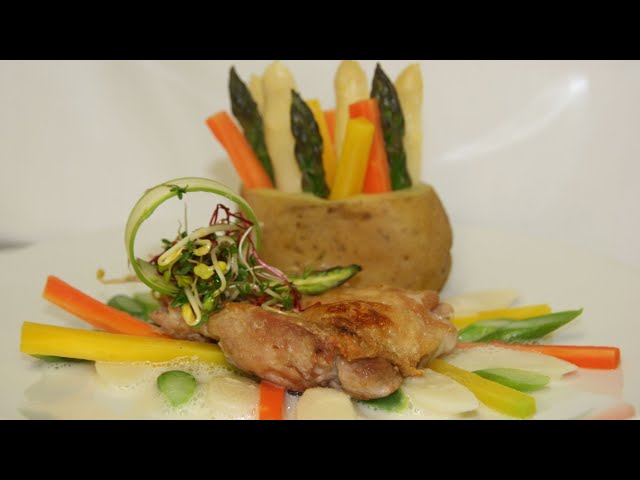 Knuspriges Hähnchensteak mit Spargelragout und bunten Möhren gefüllter Kartoffel