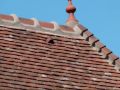 Réalisation d'une couverture en tuiles plates anciennes d'un bâtiment classé Tour N°2 Ses particularités : Un oeil de boeuf refait intégralement Une lucarne capucine Réalisation en cuivre et en plomb