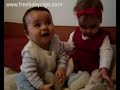 Babies playing with each other on the couch