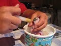 Gelbbrustara-Baby wird mit einer Spritze gefuettert