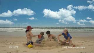 Time-lapse of four children building sand castle on beach, Byron Bay, New South Wales, Australia