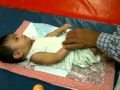 A child is being taught how to bear weight on his arm to help in raising self off the ground