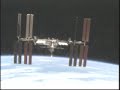Space shuttle Atlantis flies around the International Space Station after undocking.