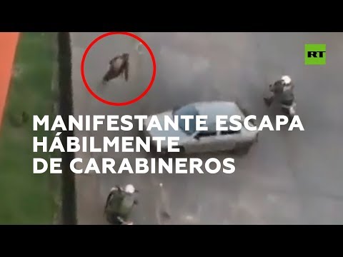 Manifestante escapa de varios carabineros que le persiguen en moto en Chile