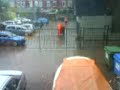 Mannen met oranje jassen in de regen