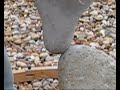 adrian gray demonstrating the delicate art of stone balancing, on the beach at lyme regis. hard to believe, and not as easy as it looks!