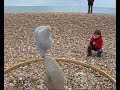 adrian gray demonstrating the delicate art of stone balancing, on the beach at lyme regis. hard to believe, and not as easy as it looks!