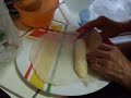 The first steps in making banana lumpia after all ingredients have been assembled. Rolling the banana slices in the sugar/cinnamon mix, and wrapping them in the lumpia wrapper.