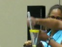 Carl Bardin is extracting venom from a Cottonmouth.  The glass has tape on the rim resembling a target. The snake bites the edge of the target.  With modification this can turn into target training with out handling the snake.