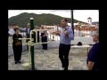 El monitor deportivo explica y enseña a los usuarios como deben usar correctamiente los aparatos de gimnasia que estan puestos en el parque infantil 