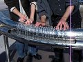 Two people playing hydraulophone (water pipe organ flute)