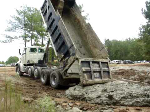Dump trucks dumping mud
