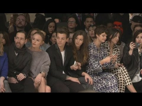 One Direction's Louis Tomlinson brings girlfriend to the Topshop show and Cara Delevingne models Video