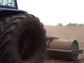 Rolling a field after sowing grass seed.New Holland