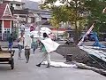 incredible footage of men in makassar, sulawesi indonesia carrying bags of sugar on their shoulders assembly line style onto a port.  you can also hear the mosques in the background. this is a very famous port town in indonesia.