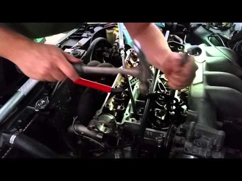 Removing valve locks from Mazda FE3 cylinder head in the car.