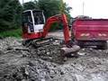 Schaeff HR14 Mini digger loading a trailer with stone