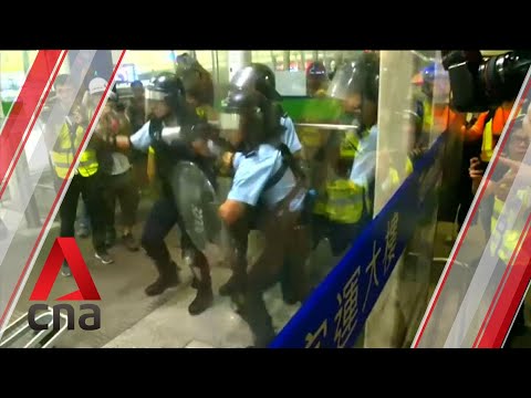 Policias antidisturbios acorralados son atacados con barras han de huir del aeropuerto de Hong Kong, por piernas.  Video