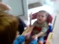 lewis in his giraffe chair, with jenna helping him to clap hands.